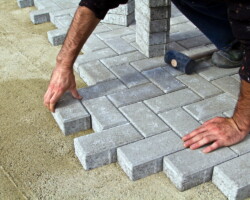 Construction of pavement. Worker puts paving